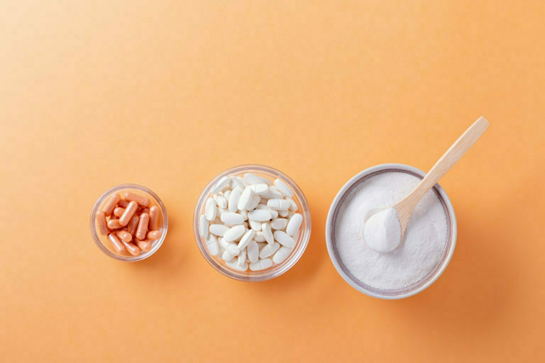 a pair of spoons next to a bowl of pills