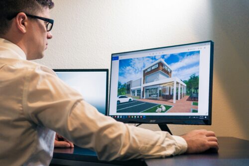 a man sitting in front of a computer monitor