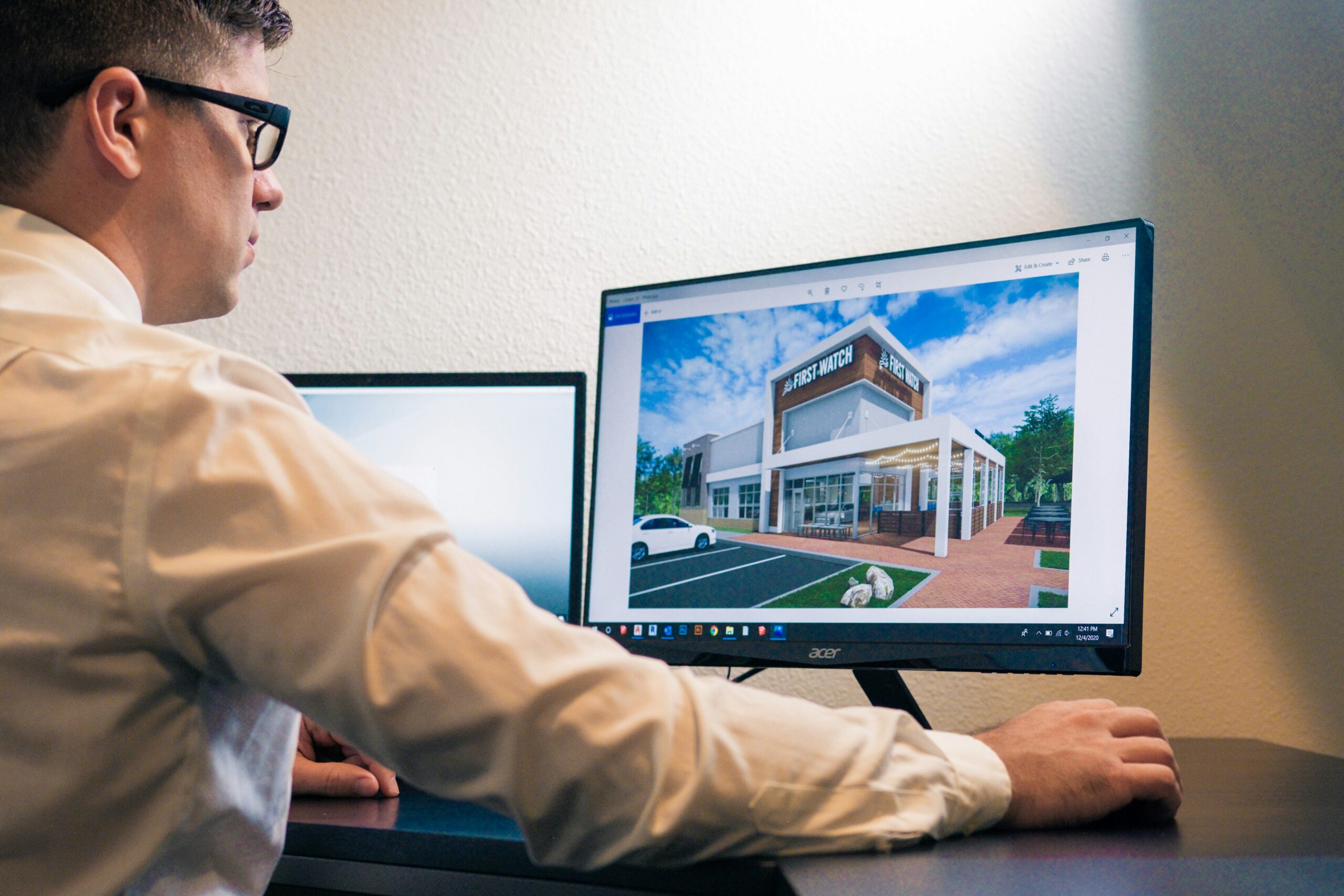 a man sitting in front of a computer monitor