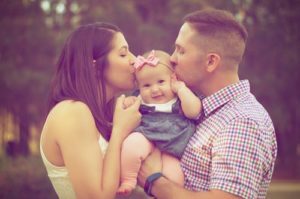 a man and woman holding a baby