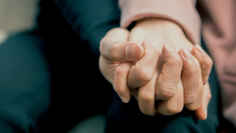 a close-up of a person holding the hands together