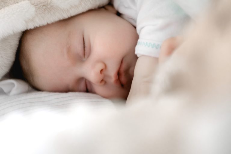a baby sleeping on a bed