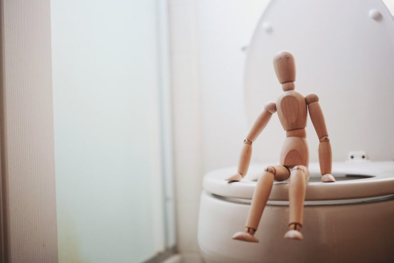 a naked woman sitting on a toilet