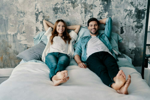 a man and woman lying on a bed