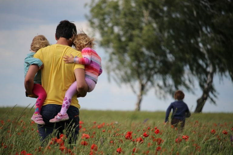 a group of people standing in a field of flowers