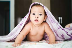 a baby sitting on a bed