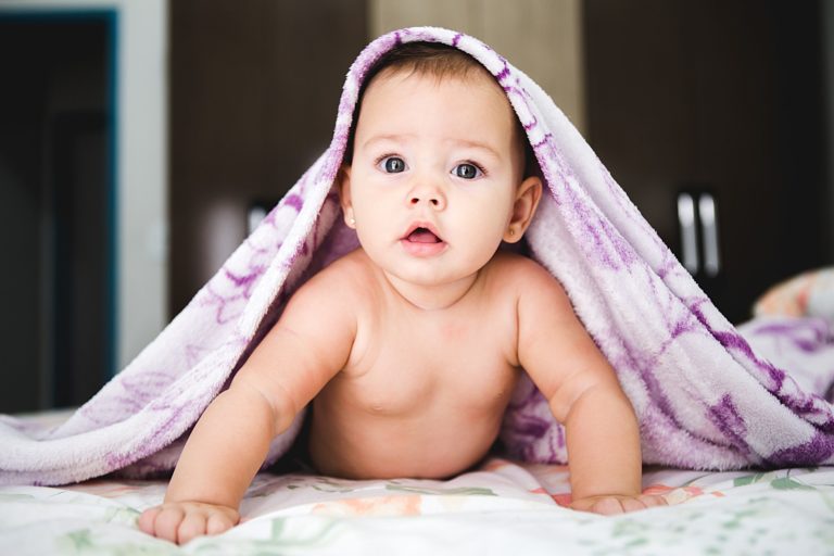 a baby sitting on a bed