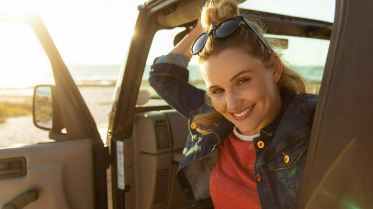 a person wearing sunglasses and a red coat in a vehicle